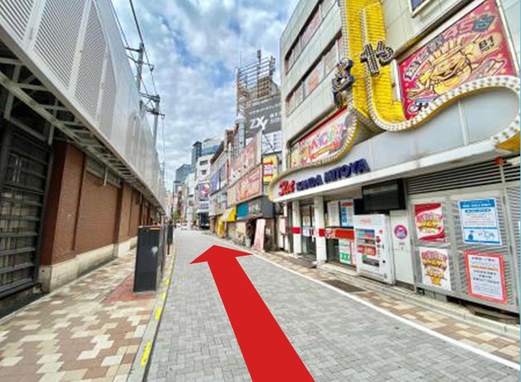 Pass by the Pachinko parlor and go straight along the elevated tracks.