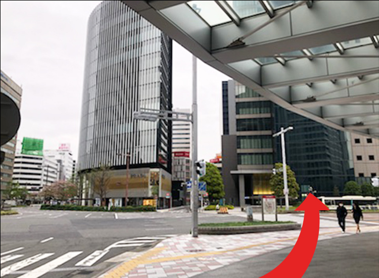 Go out to the main road and walk straight across the pedestrian crossing toward the building on the other side.