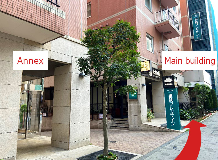 After exiting, you will see our hotel on your left in about a minute. The building in front of you is the annex, and the building at the back, which is about 20 meters away, is the main building. Please go through the check-in process at the main building.