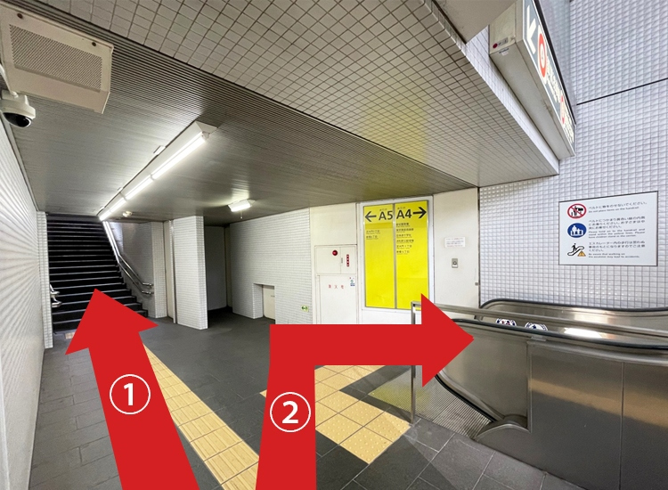 If you are using the stairs, take exit A5 (①). If you are using the escalator, take exit A4 (②).