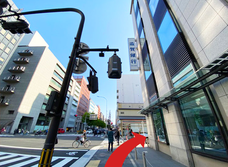在第一个十字路口向右转, 然后直走。(7-11便利店和滋贺银行是标识。)