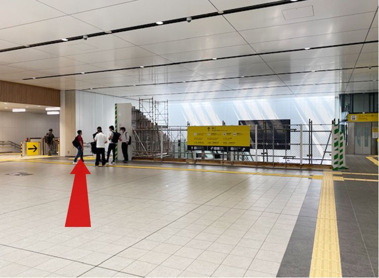 There is a construction site at the end of the road. There is an elevator at the far right and a staircase and escalator on your left, so you can take any of those to go down.